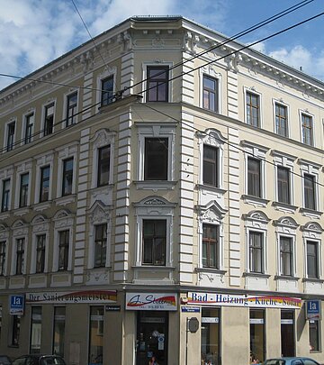 Beige, weißer Altbau mit Geschäft im Erdgeschoss